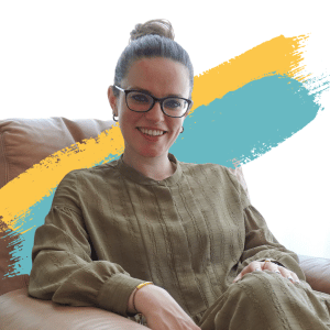 Picture of Alexandra Birtles, co-founder of In Good Company. Alex is a white woman with brown hair and glasses. She has her hair up in a bun and is wearing a green dress.